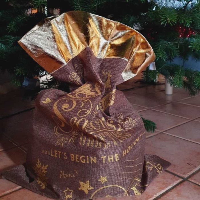 Grand sac cadeau tissu Noël marron or réutilisable 50x70 cm posé sous le sapin